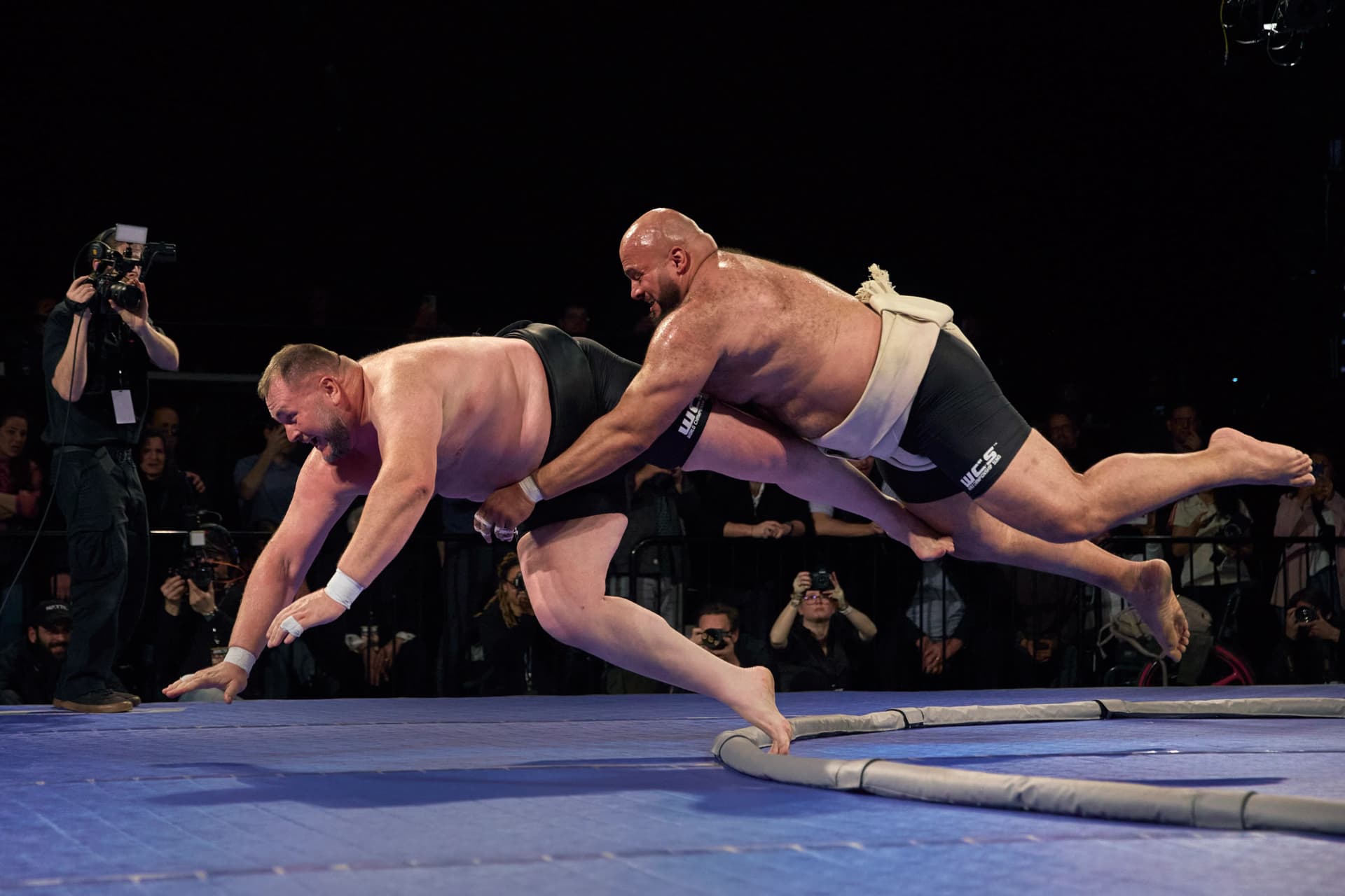 Rikishi driving his opponent out of the ring